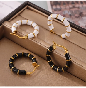 Close-up of bamboo style U-shaped hoop earrings with enamel details in a jewelry box