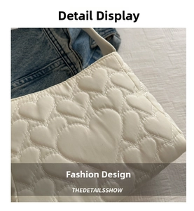 Gros plan sur les motifs de cœur matelassés d'un sac à bandoulière blanc crème doux