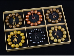 Detailed view of six diverse wooden Buddhist prayer beads in a premium divided gift box