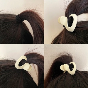 Creamy white matte claw clip tutorial for securing high ponytail and voluminous hairstyle