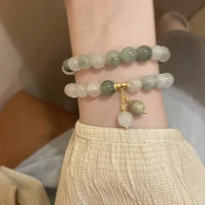 Detailed shot of double-layer beaded bracelet featuring green and translucent white jade beads