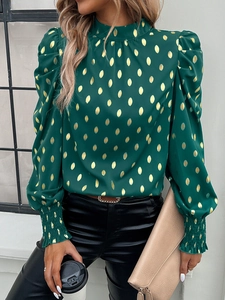 Detail of elegant dark green blouse with gold polka dots and stylish puff sleeves