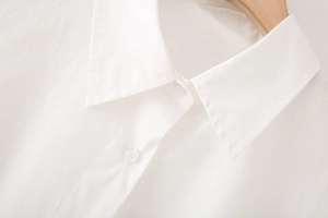 Close-up of white cotton poplin shirt collar with neat stitching and clear buttons