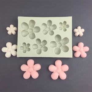 Detail of 16-cavity white silicone flower mold with finished pink and white resin blossoms