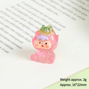 Close-up of a mini resin dragon fruit figurine with a pink bow on an open book