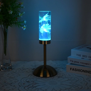 Detail of creative jellyfish desk lamp with blue glow and gold base on a lace tablecloth