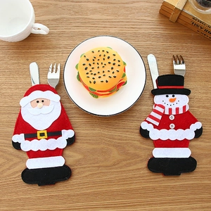 Pochettes à couverts de Noël avec motifs Père Noël et bonhomme de neige sur table