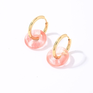 Vue détaillée d'une créole en acier inoxydable doré avec pendentif donut en résine rose