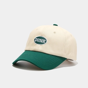 Detail of the DUNK embroidery patch on a vintage cream and dark green baseball cap