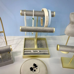 Présentoir à bijoux élégant en métal doré avec plateau en velours gris pour colliers