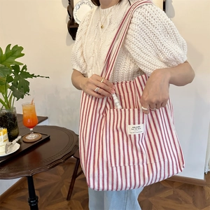 French style red striped canvas tote bag detail on shoulder in a cafe setting