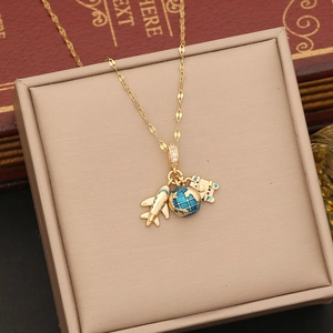 Detail showing gold plane, blue enamel globe and passport charms on a sparkling chain
