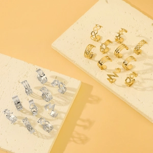 Detail of gold and silver open rings with heart and star patterns on stone display