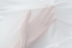 Close-up of semi-transparent white mesh fabric showing lightweight breathable texture