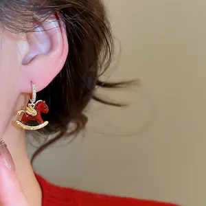 Boucles d'oreilles cheval à bascule en émail rouge avec ailes dorées et zircons scintillants