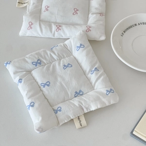Close-up of bowknot pattern printed on padded cotton coaster with soft texture