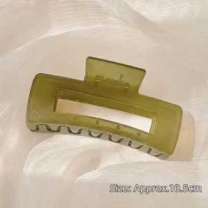 Macro detail of a 10.5cm olive green square hair claw clip on soft silk fabric