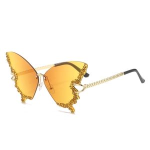 Frameless butterfly sunglasses with orange gradient lenses and diamond embellishments