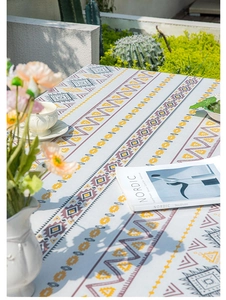 Detail of bohemian linen tablecloth featuring geometric patterns and fringe edges