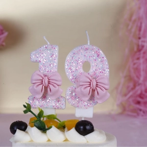 Macro shot of glittery pink and purple number 18 candles with 3D bows on a cake