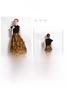 Detail of elegant black high-neck top and gold jacquard maxi skirt showing fabric texture