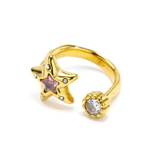 Detail of gold starfish ring with pink star zircon and white stones on white background