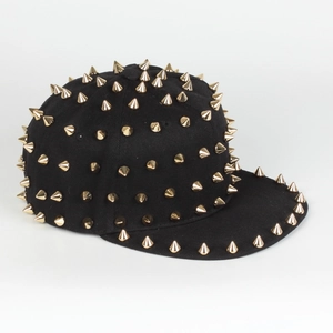 Detailed view of gold metal spiked rivets on a black punk flat brim hip hop cap