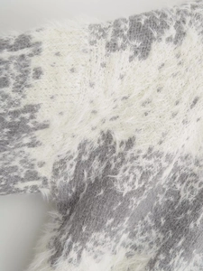 Detailed macro shot of fuzzy long-hair knit cardigan in grey and beige contrast panels