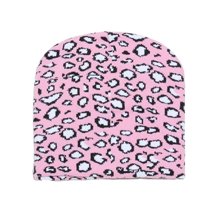Detailed close-up showing the soft pink leopard print knit fabric texture of the beanie