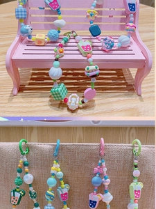 Détail de perles en résine macaron et breloques de fruits sur ces bijoux de téléphone