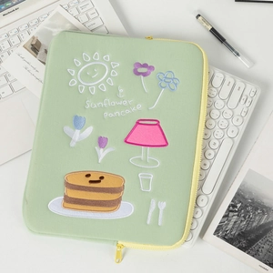 Detail of light green laptop sleeve with sunflower pancake embroidery and yellow zipper