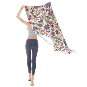 Microfiber beach towel with vintage floral patterns and tassels held by a model