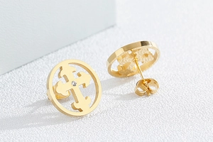 Detail of gold cross stud earrings with white crystal inlay and hollow round frame