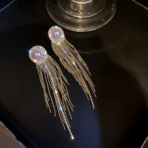 Détails de boucles d'oreilles dorées à pompons avec perles et franges en cristal brillant