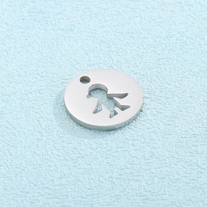 Macro detail of silver stainless steel round pendant with hollow girl silhouette cutout