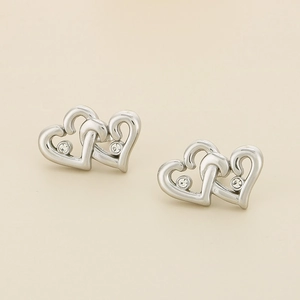 Macro view of interlocking heart earrings in silver with sparkling white rhinestones