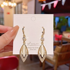 Detail of elegant gold-plated drop earrings with marquise stones and zircon accents