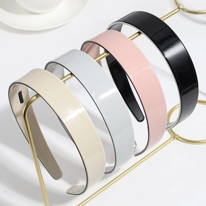 Detail of four matte pastel nonslip headbands in beige, grey, pink, and black colors