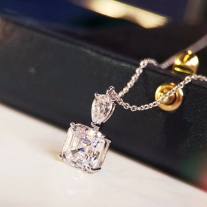 Macro shot of a silver necklace featuring square and teardrop cut sparkling crystals