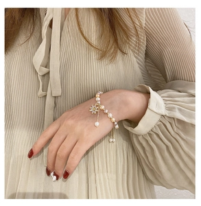 Close-up of multicolor freshwater pearl bracelet with zircon flower pendant on wrist