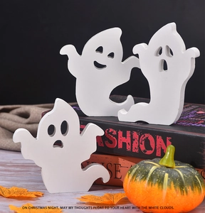Set of three cute white wooden ghost signs on table with pumpkins and autumn leaves