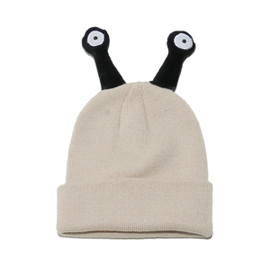 Detailed view of cream knit beanie featuring funny black decorative antennae and ribbed texture
