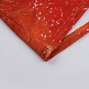 Détail du tissu imprimé rouge avec motifs blancs et finitions soignées des coutures