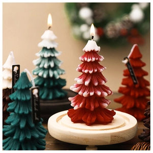 Handmade Christmas tree scented candles in various colors on wooden bases with festive decor