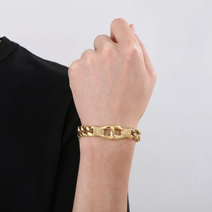 Close-up of men's chunky golden Cuban link bracelet on wrist with vintage totem clasp
