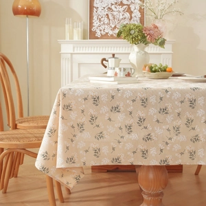 Close-up of a floral cotton linen tablecloth with beige, white and dark green motifs