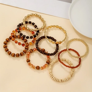 Detail of bohemian multilayer stacked bracelet set with wood beads and metallic accents