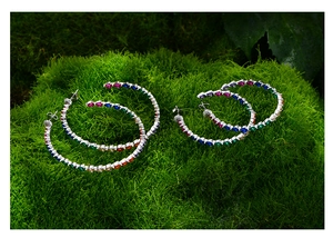 Detailed macro view of rainbow cubic zirconia hoop earrings on green moss background