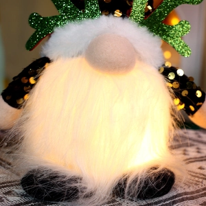 Close-up of a glowing Christmas gnome with sequined arms and green reindeer antlers