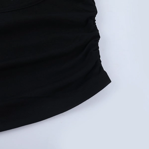 Détail macro du tissu côtelé noir avec design plissé élastique pour ce haut court chic